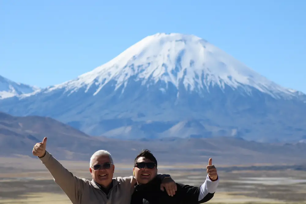 Amigos saludando frente al volcán Parinacota