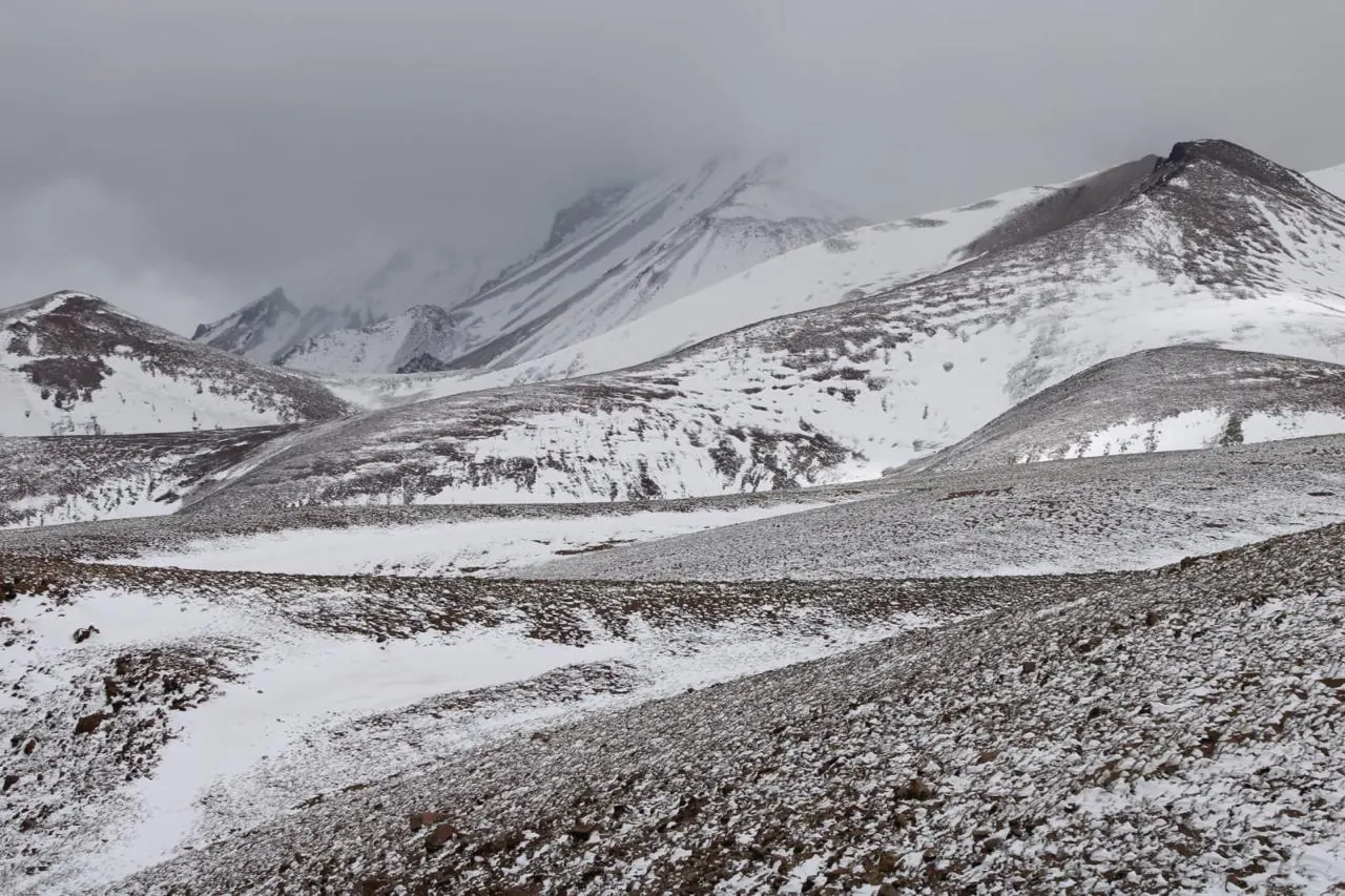Cerros del altiplano nevados bajo cielo nublado