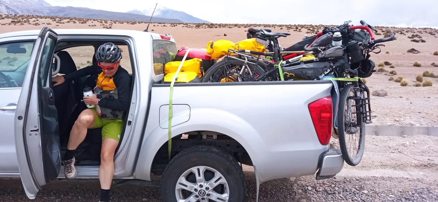 Ciclista bajando de la camioneta junto a las bicicletas de bikepacking cargadas