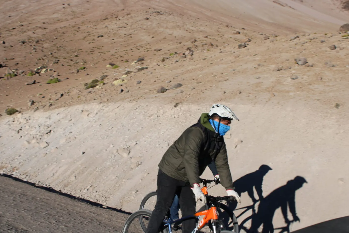 Ciclista en primer plano con su sombra proyectada en el camino