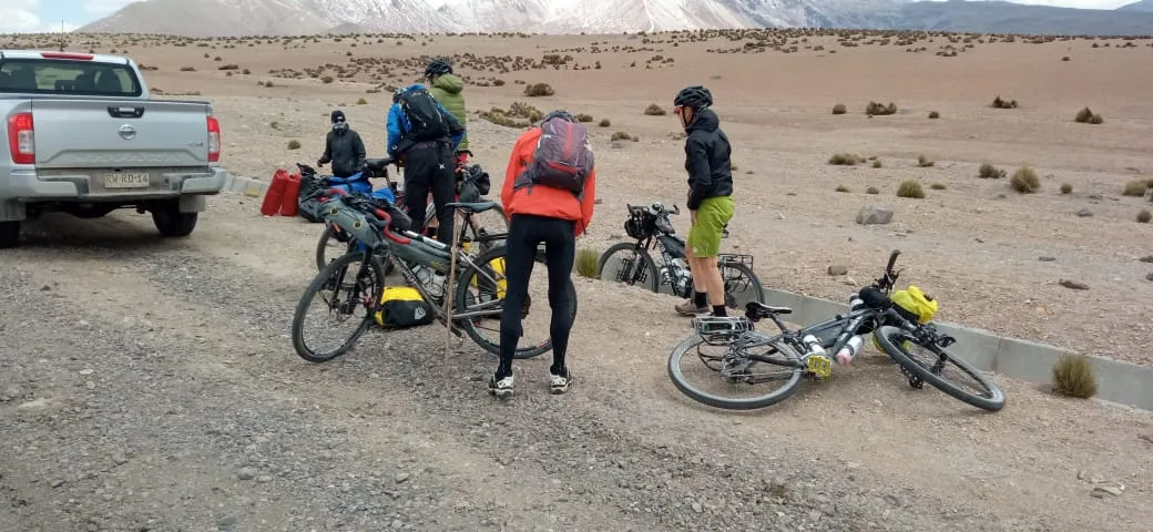 Grupo de ciclistas bikepackers acomodando sus bicicletas junto a la carretera