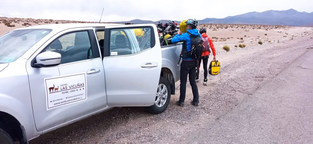 Ciclistas cargando sus alforjas junto a la camioneta del Hotel Las Vicuñas