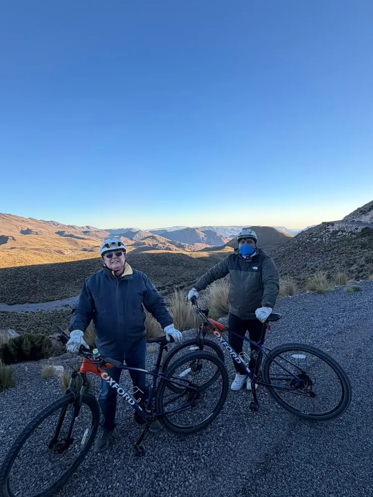 Dos ciclistas posando con sus bicicletas en el altiplano