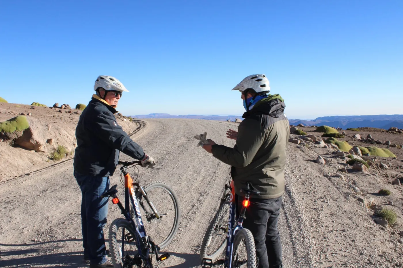 Ciclistas pedaleando por camino de ripio bajo el cielo del altiplano