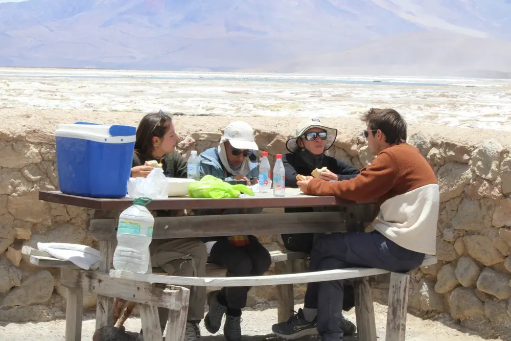 Grupo de pasajeros compartiendo un picnic en el altiplano