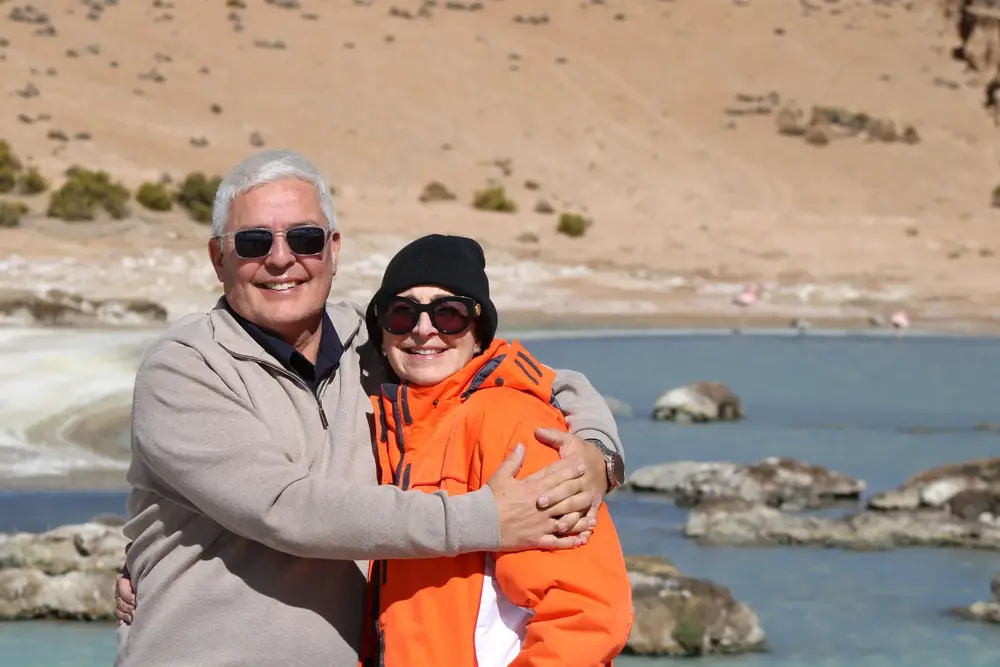 Pareja abrazada frente a una laguna del altiplano