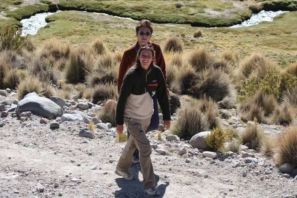 Pareja caminando por un sendero rocoso del altiplano