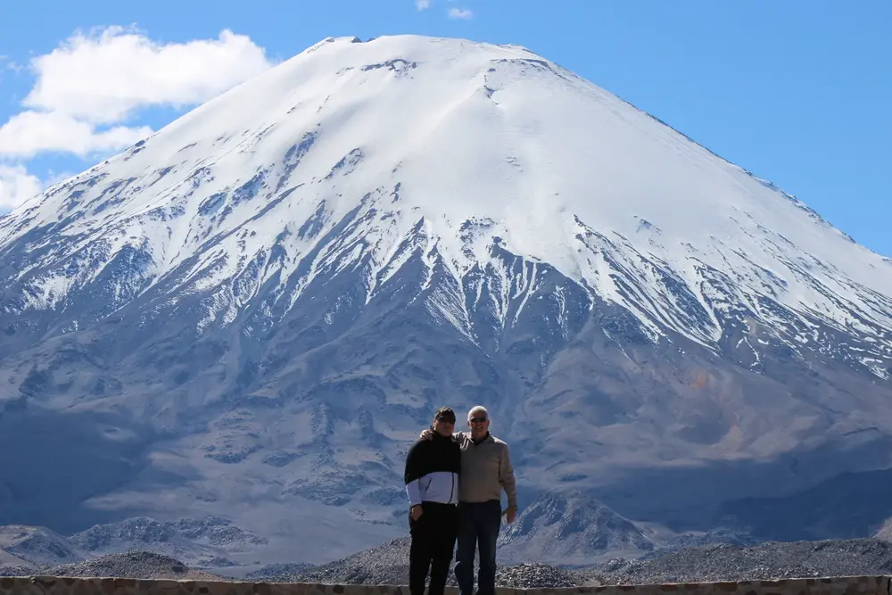 Pareja de pasajeros frente al volcán Parinacota