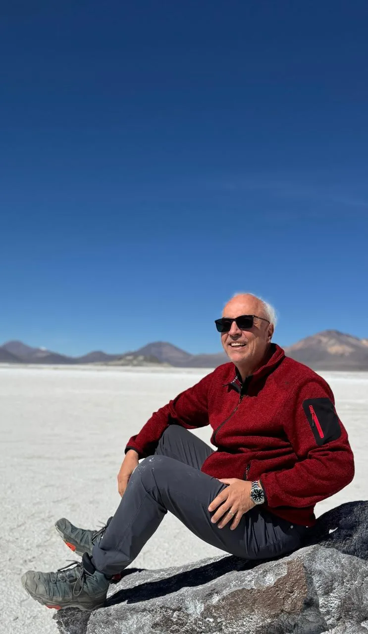 Roberto Cattán sentado sobre una roca en el Salar de Surire