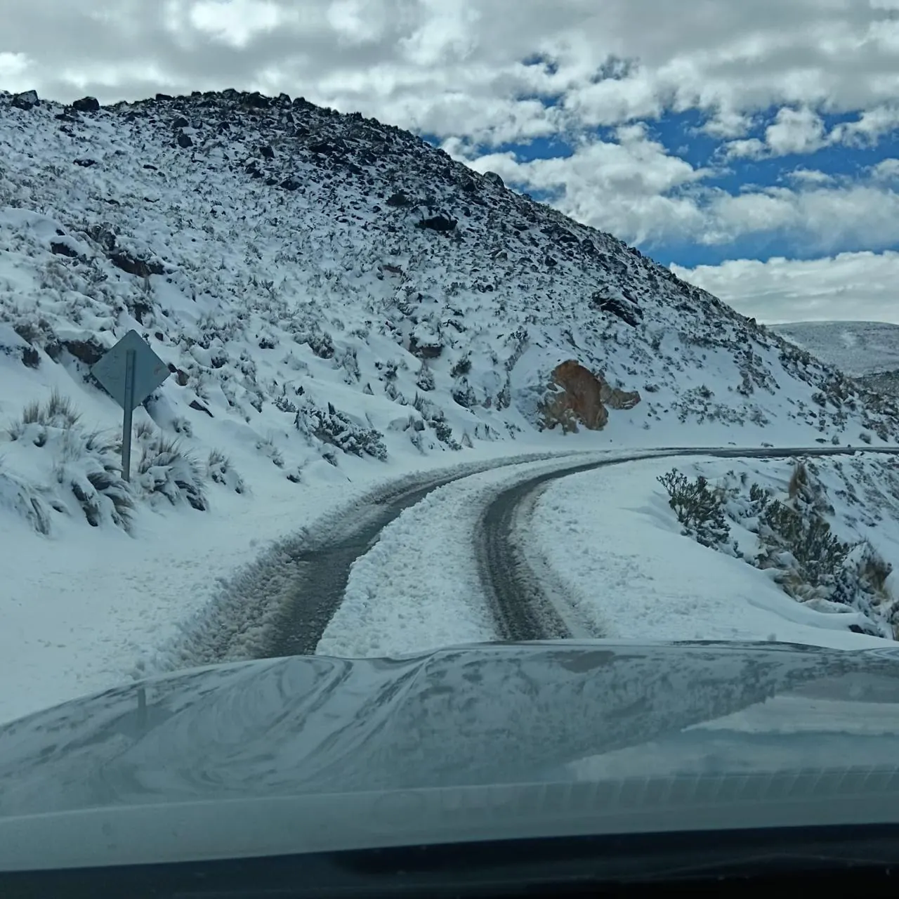 Ruta del altiplano cubierta de nieve, vista desde el vehículo