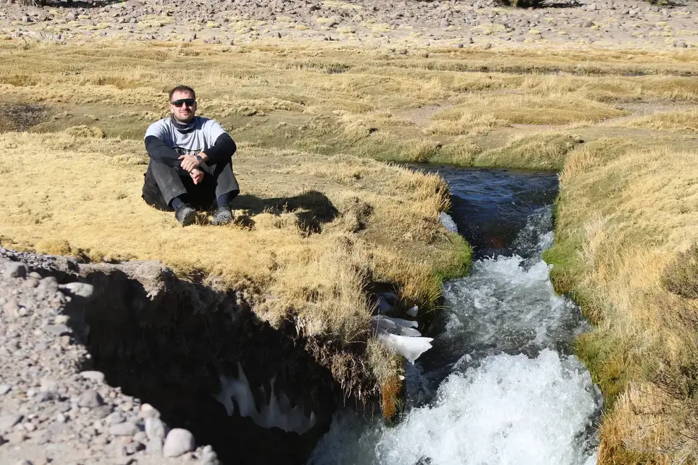 Turista contemplando un arroyo en el bofedal altiplánico